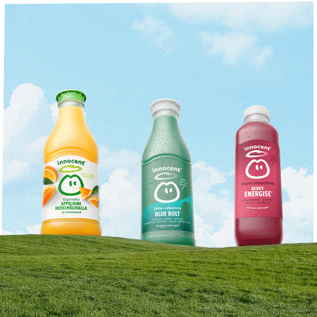 a innoccent juice, super smoothie and juice + vitamins in a grass hill and a sky background
