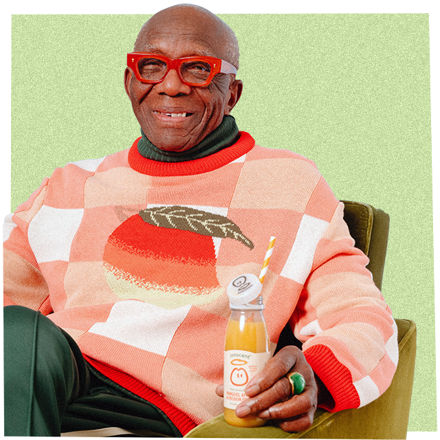 a man wearing a big knitwear jumper and drinking an innocent smoothie